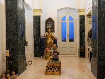 Di fronte si trova un terzo ambiente: � particolarmente luminoso, ma solenne. La statua di un santo si erge al centro, un'altra brilla sul fondo a sinistra: siamo infatti nella cappella di famiglia